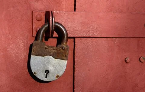 Closeup of old lock on red metal garage door Stock Photos