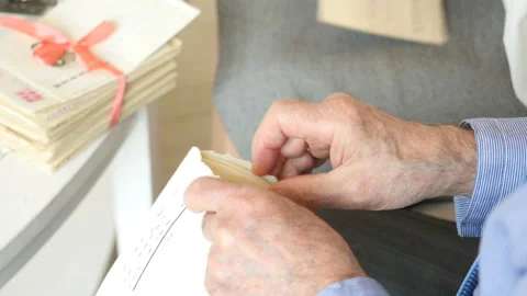 Closeup of the old man's hands opening letter, reading old letters. Old couple Vidéo 99692616