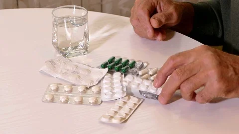 Closeup of old man's hands with pills on the table Video stock 71889121
