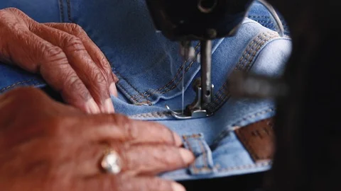 Closeup of old man's hands sewing with a sewing machine Stock Footage 120495812