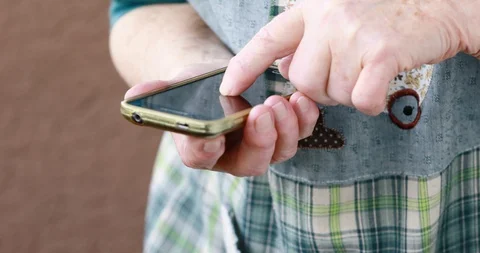 Closeup of old person's hands handling a smartphone Stock Footage 129721491