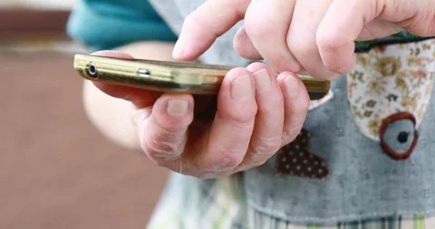 Closeup of old person's hands handling a smartphone Stock Footage 129721620