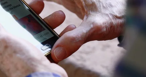 Closeup of old person's hands handling a smartphone Stock Footage 129721828