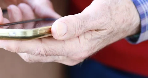 Closeup of old person's hands handling a smartphone Stock Footage 129722161