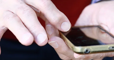 Closeup of old person's hands handling a smartphone Stock Footage 129722229