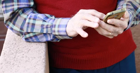 Closeup of old person's hands handling a smartphone Stock Footage 129722465