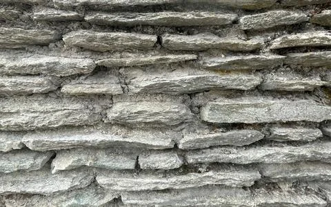 Closeup of an old rough stone wall texture with cement mortar showing weath.. 스톡 사진