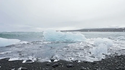 Closeup of one cold winter blue glacier iceberg diamond beach in Iceland, black Stock Footage 92764646