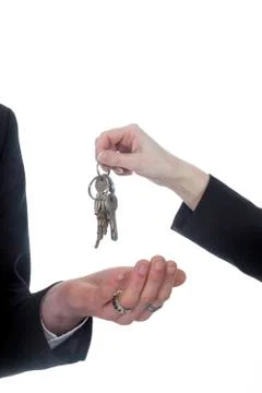 Closeup of one hand with key ring hands over keys to other hand Stock Photos