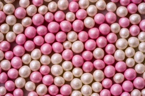 Closeup of one layer of pink and white sugar pearls (cake decor), from above Stock Photos