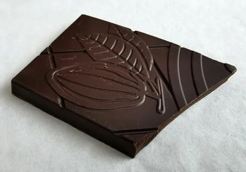 Closeup on one square piece of dark chocolate Stock Photos
