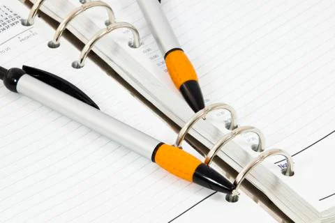 Closeup of open diary with two ballpoint pens Stock Photos