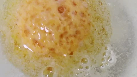 Closeup orange bath bomb spinning and fizzing bubbles Stock Footage 334053465