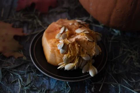 Closeup of orange pumpkin inside clean out with many seeds on a rustic table Stock Photos