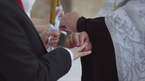 Closeup Orthodox priest performing rite of exchanging rings for marrying Stock Footage 83485867