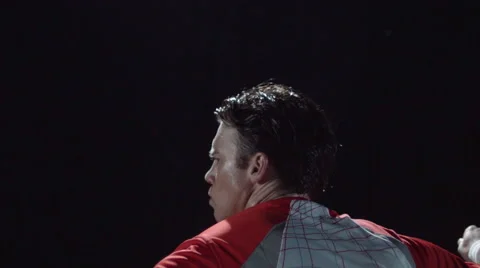 Closeup over the shoulder of a man playing tennis on court at night Stock Footage 63821619