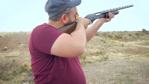 Closeup of an Overweight Man Shooting a 12 Gauge Shotgun at a Desert Gun Range Stock Footage 88559258