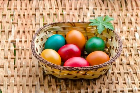Closeup paint Easter eggs in the basket on wicker table Foto stock