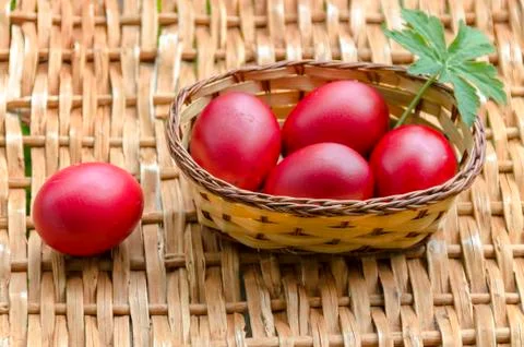 Closeup paint Easter red eggs in the basket on wicker table Stock Photos