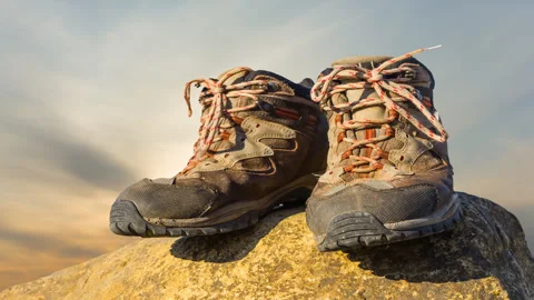 Closeup pair of touristic boot stay on a stone at the sunset Stock-Footage 312372841