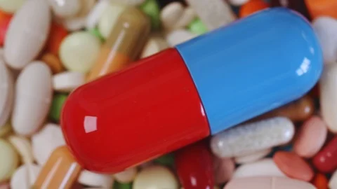 Closeup pan shot of stack of pills with large center pill Stock Footage 95912850
