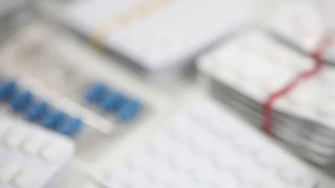 Closeup pan shot of stacks of blisters of medication Stock Footage 124636322