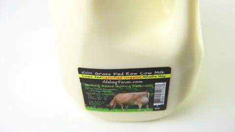 Closeup panning one gallon raw unpasteurized cow dairy milk from Florida Stock Footage 179538653