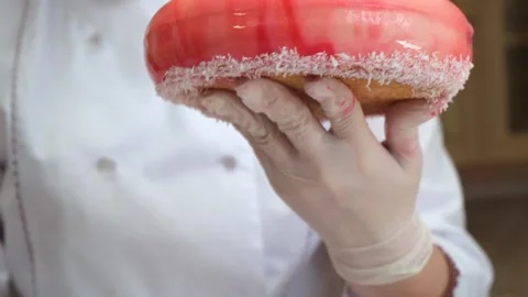 Closeup, pastry chef hand decorates with white coconut shavings bottom of the Stock Footage 148838992