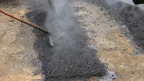 Closeup of patching a bump in the road with new asphalt Stock Footage 237213400