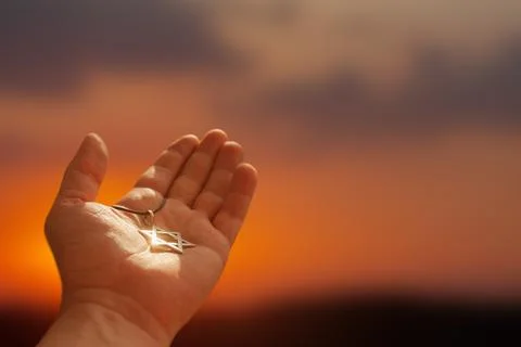 Closeup of pendant in the shape of the star of david on the hand of a man on Stock Photos