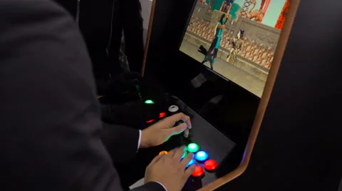 Closeup people playing video game machine. Mortal Combat 3. 4K. Man in suit play Stock Footage 68980757