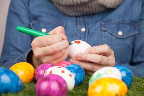Closeup of a person drawing patterns on eggs with markers for Easter 스톡 사진