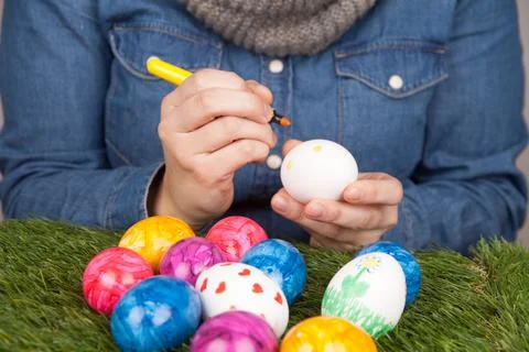 Closeup of a person drawing patterns on eggs with markers for Easter 스톡 사진