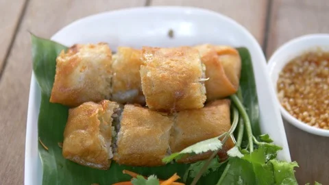 Closeup person picking up spring roll with chop stick Stock Footage 123104188