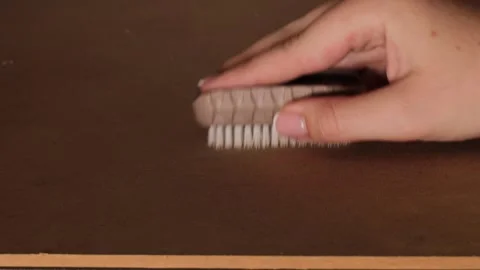 Closeup of a person using a small stiff-bristled cleaning brush to scrub a flat Stock Footage 327683009