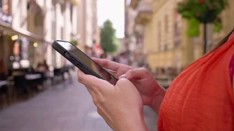 A closeup of a person using a smartphone on a busy street in Budapest, lifestyle Stock Footage 293502314