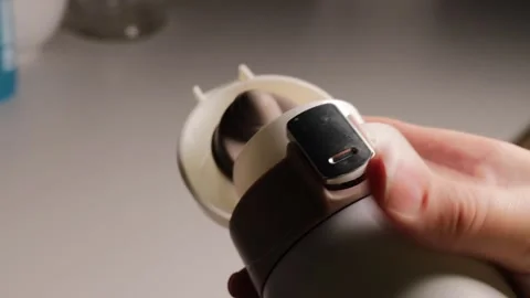 Closeup of a persons hands operating the lid of a sleek thermos bottle, Stock Footage 327682825