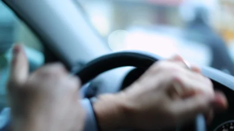 Closeup of person's hands on steering wheel driving car. Man driving a vehicle. Stock Footage