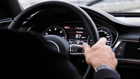 Closeup of person's hands on steering wheel driving car. Man driving a vehicle. Vidéo 100757844