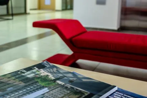A closeup perspective shoot of a red sofa - focus on magazines Foto stock