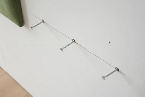 A CloseUp Perspective of Wall Mounted Hooks and Wire Arrangement for Enhancing Stock Photos