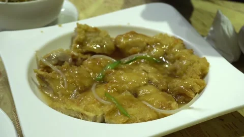 Closeup of a peruvian chifa plate of chijaukay chicken chunks on the table Video stock 161444571