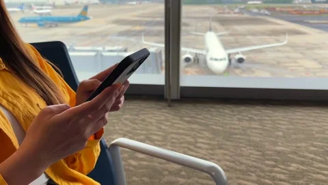 Closeup of phone usage with planes in the background Stock Footage 308878481