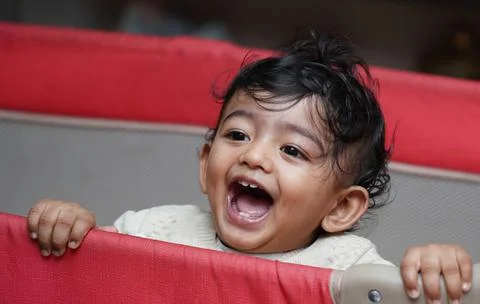 A closeup phot of an adorable indian toddler baby boy smiling with dimple in Stock Photos