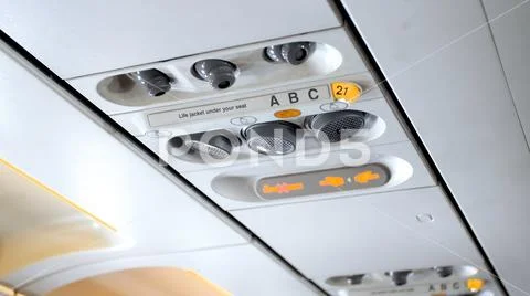 Closeup photo of buttons and lights on the ceiling above the pasenger seat in Stock Photos