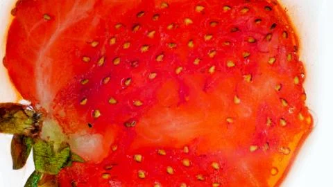 Closeup photo of crushed and squeezed stawberry over white backgrund. Abstract Stock Photos