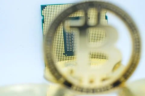 Closeup of physical bitcoin and computer cpu processor 写真素材