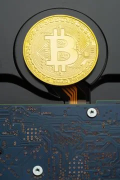 Closeup of physical Bitcoin criptocurrency coin on hard disk drive Stock Photos