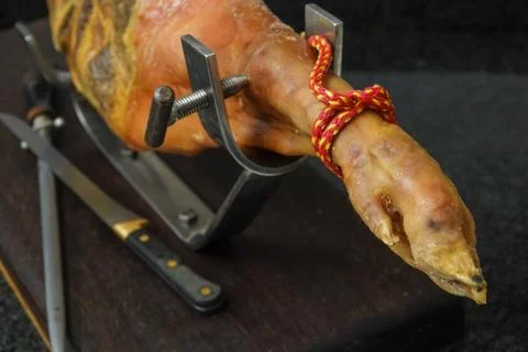 Closeup of a piece of pork meat's thigh on a steel holder Stock Photos