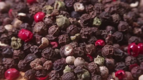Closeup of a pile of colored peppercorns on a bamboo cutting board. Macro shot. Stock Footage 140110112